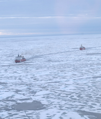 Photo of the two ships in the ice in seismic operation mode, with the Healy breaking ice in front of the Louis. photo by Hans Böggild.