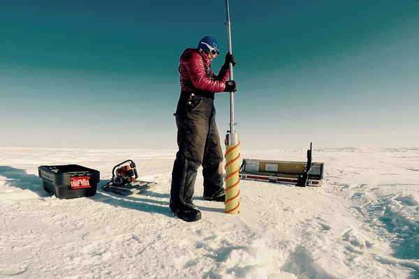 I'm using a Kovacs shallow ice coring drill to extract a core from the summit of Ellesmere Island's Agassiz Ice Cap. The shotgun is for polar bear safety! We use a special power head that assists ice core scientists in drilling shallow cores.