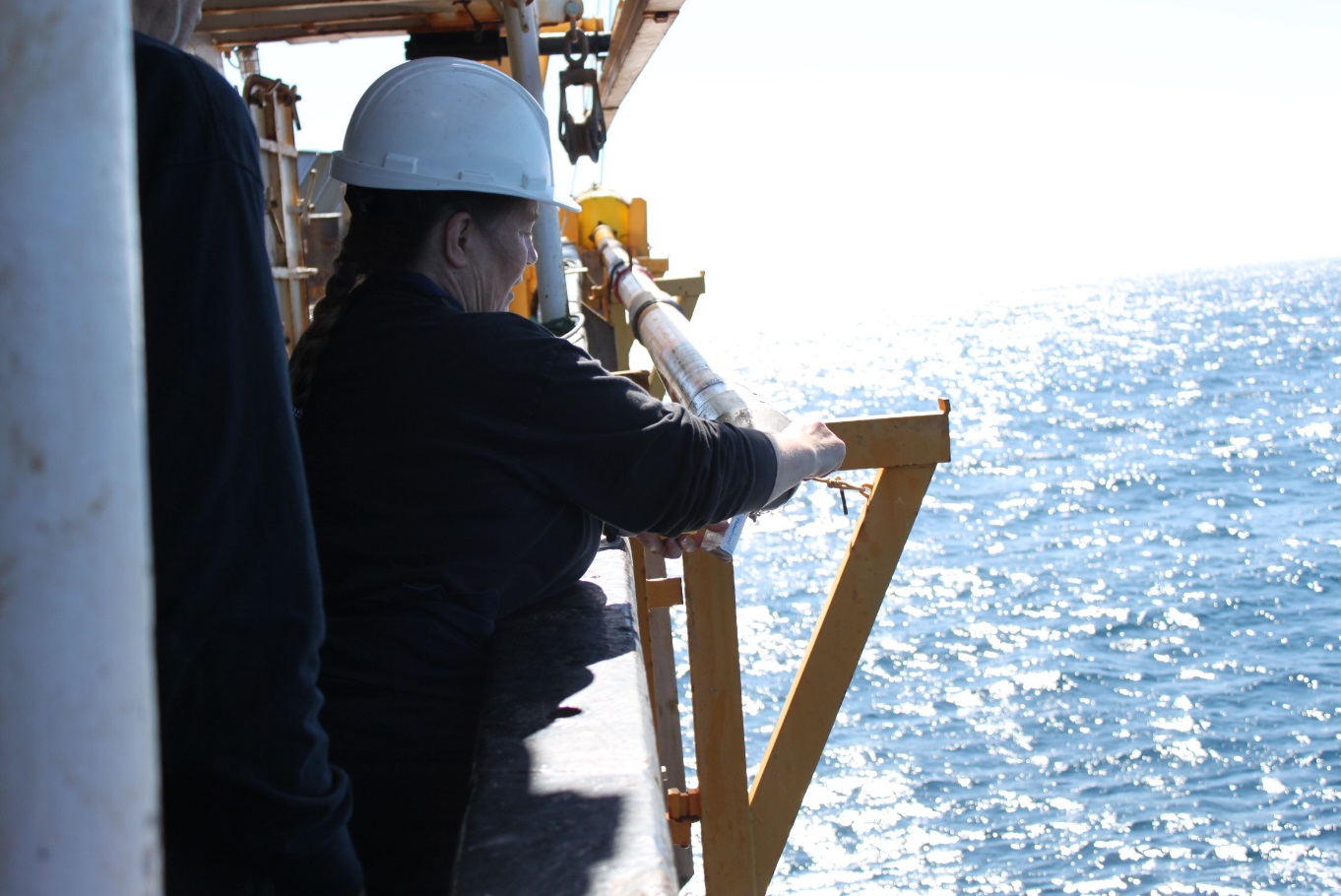 The GSC Atlantic’s Kate Jarrett subsampling the base of a marine sediment core onboard the CCGS Hudson.