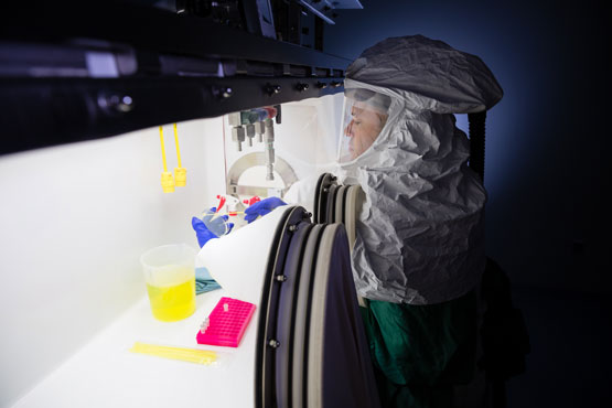 A scientist works in a high containment laboratory.