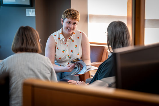 Three people seated talking