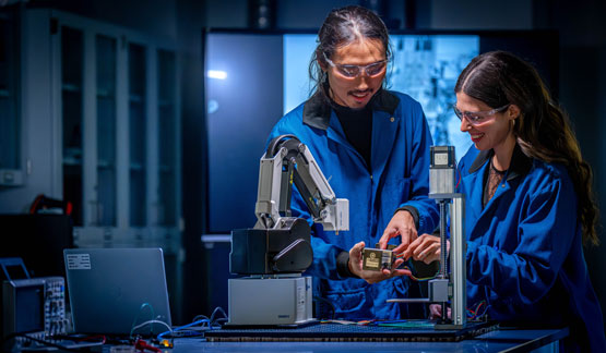Two people examining a component
