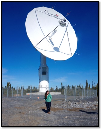 Laura devant l'antenne ICAN1 à la station-relais pour satellites d'Inuvik (SRSI) à Inuvik, T.N.-O.