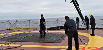Seismic crew assemble the hydrophone streamer (eel) on the helideck prior to spooling on to the winch