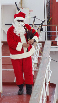 Le père Noël (Mark Rowsome) joue de la cornemuse à bord du Healy pendant que le carburant est acheminé sur le St Laurent.