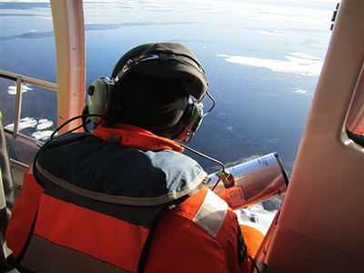 L'expert scientifique en chef déploie une bouée acoustique à partir de l'hélicoptère. Photo par Steve Wackowski (US Air Force).