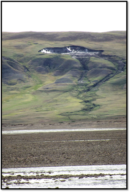 A permafrost slump on Banks Island, NWT. The previously frozen ground has thawed and collapsed, flowing into the river.