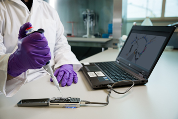 Un membre du personnel scientifique du LNM utilise un instrument portatif de séquençage de génome 